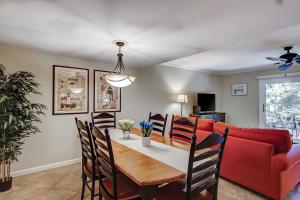 a living room with a table and a red couch at Stones Throw 30 in Hilton Head Island