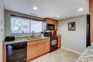 a kitchen with wooden cabinets and a black dishwasher at Stones Throw 30 in Hilton Head Island +74 photos