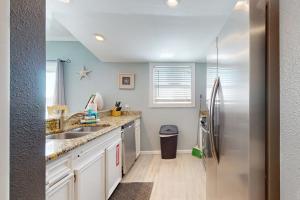 a kitchen with a sink and a refrigerator at Seas the Day in Port Aransas +24 photos