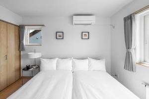 a white bed with white pillows in a bedroom at THE VERTEX - Vacation STAY 20147 in Shin-asahigawa