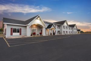 a row of white buildings in a parking lot at Baymont by Wyndham Marinette in Marinette