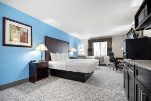a hotel room with a bed and a television at Baymont by Wyndham Marinette in Marinette