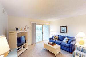 a living room with a blue couch and a tv at Bluff Villas 1733 in Hilton Head Island