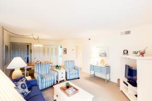 a living room with two blue chairs and a tv at Bluff Villas 1733 in Hilton Head Island