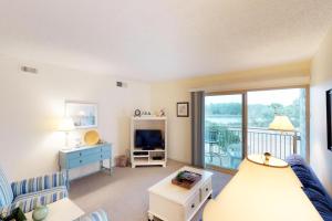 a living room with a couch and a tv at Bluff Villas 1733 in Hilton Head Island