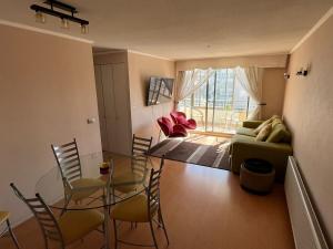 a living room with a glass table and chairs at Steps from Everything in Viña del Mar