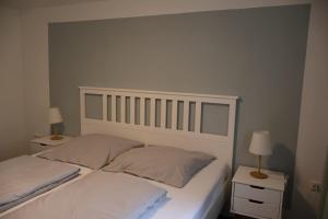 GrebendorfにあるFerienwohnung Miraの白いベッドと2つのナイトスタンドを備えた寝室