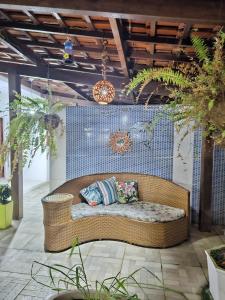 a wicker couch sitting in the middle of a room at Pousada Asahi in Porto De Galinhas