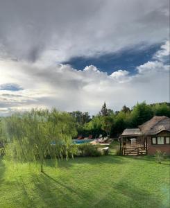 a house in a field with a grass yard at Casas de Campo Hoja in Chascomús
