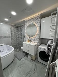 a bathroom with a tub and a sink and a bath tub at Lovely Flat with Great Central Location Kaunas in Kaunas