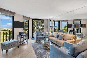 Una sala de estar con un sofá y sillas y ventanas. en SW122D: 122D Shipwatch, en Isle of Palms