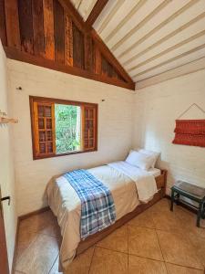 a bedroom with a bed in a room with a window at Cabana Arara - Terroir Mantiqueira in Paiol Grande