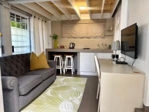 a living room with a couch and a kitchen at Musgrave Avenue Guest Lodge in Durban