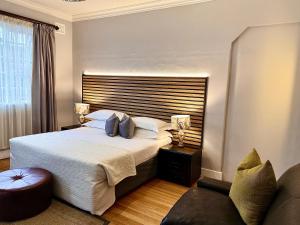 a bedroom with a large bed and a couch at Musgrave Avenue Guest Lodge in Durban