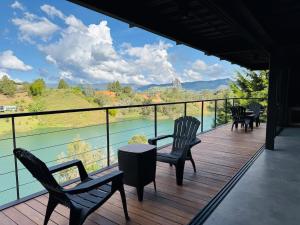 a balcony with chairs and a table and a view of the water at Exclusive Villa - Lake View - Forest in La Pradera