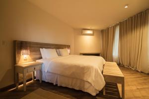 Una habitación de hotel con una cama, una mesa y una ventana. en Bela Vista Hotel Boutique, en Caraíva