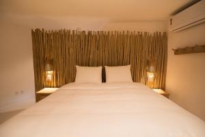 Un dormitorio con una gran cama blanca con dos lámparas. en Bela Vista Hotel Boutique, en Caraíva 79 fotos más