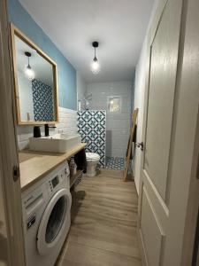 a bathroom with a sink and a washing machine at Casa del arroyo in Caserío Arroyofrío