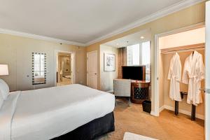 a hotel room with a large bed and a television at The Signature at MGM Grand, Luxury Balcony Suite, Strip View in Las Vegas