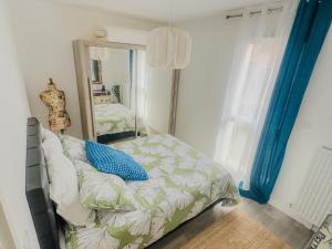 a bedroom with a bed and a large mirror at Le Cosy Chic - F2 in Carrières-sous-Poissy