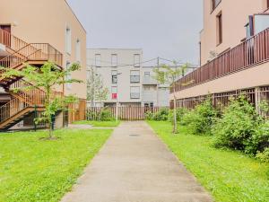 a walkway in an apartment complex with buildings at Le Cosy Chic - F2 in Carrières-sous-Poissy