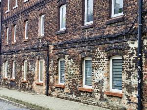 a brick building with lots of windows on a street at Friendly Apartment Wełnowiec in Katowice