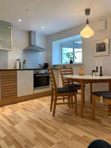 a kitchen with a table and a dining room at F27-K, 4 people, 4 bedrooms, fully furnished in Aalborg