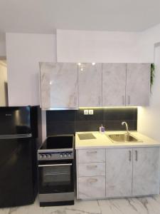 a kitchen with a black refrigerator and a sink at Valaoritou Luxury Jacuzzi by Dimcol 2 in Thessaloniki