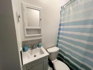 a bathroom with a sink and a toilet and a mirror at Wolfville Veranda Suite2 in Wolfville +7 photos