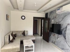 a living room with a couch and a flat screen tv at Royal house Near Airport in Khuraybat as Sūq