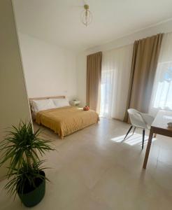 a bedroom with a bed and a plant in it at Ama Family in Marotta