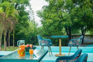a patio with chairs and a table with fruit on it at Hidden Gem near Jaipur horse ride, scenic view & swimming pool in Pachār
