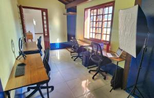 a classroom with desks and chairs with laptops on them at Casa Maré Floripa - Coliving, Coworking and Community in Florianópolis