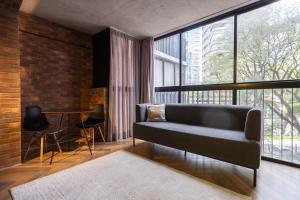 a living room with a couch and a table with chairs at Housi Faria Lima in Sao Paulo