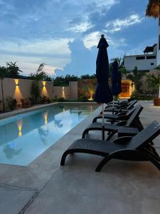 basen z leżakami i parasolami przed hotelem w obiekcie Casa Jubilee 6 two twins or king w mieście Puerto Escondido