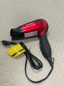 a red blow dryer with a tag on it at Apartamento compartilhado em Guarapuava - Quarto 3 in Guarapuava
