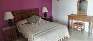 a bedroom with a bed and a desk and a mirror at Casa en renta, fraccionamiento Victoria, Oaxaca in Oaxaca City +4 photos