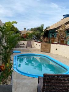a large blue swimming pool in a yard at Pousada Hanalie by Easy Hotéis in Praia do Rosa