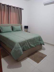 Un dormitorio con una cama con un edredón verde. en Luxury Beachside Escape 3BR 2BA with Pool & Ocean Views, en San Felipe de Puerto Plata