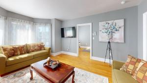 una sala de estar con un sofá y una mesa en Wolfville Central 4 Family Suite with Style, en Wolfville 6 fotos más