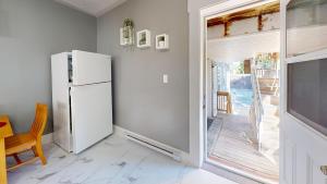cocina con nevera y puerta corredera de cristal en Wolfville Central 4 Family Suite with Style, en Wolfville