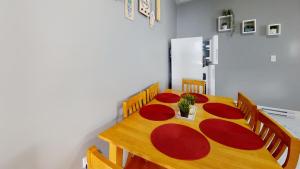 mesa de comedor con platos y sillas rojos en Wolfville Central 4 Family Suite with Style, en Wolfville