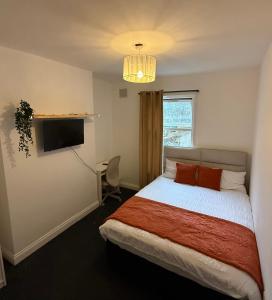 a bedroom with a bed and a tv and a window at Saint Paul 02 in Bristol