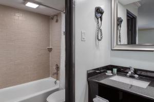 a bathroom with a sink and a toilet and a phone at Best Western Webster Hotel, NASA in Webster +18 photos
