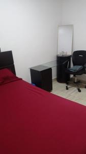 a bedroom with a red bed and a desk and chair at Colibri - Hab Doble in Lima
