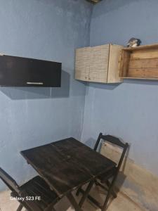 a wooden table and a chair in a room at Recanto do Leâo in Guarujá