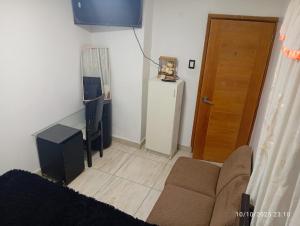 a living room with a couch and a table and a television at Colibri - Hab Doble in Lima