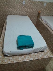 a bed with a blue pillow on top of it at Casa de Lazer e Eventos Monte Sião in Paulo Afonso