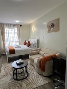 un salon avec un canapé et un lit dans l'établissement Favour cozy stay 24, à Nairobi