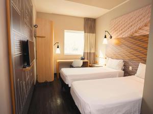 a hotel room with two beds and a television at ibis Sao Bernardo do Campo in São Bernardo do Campo